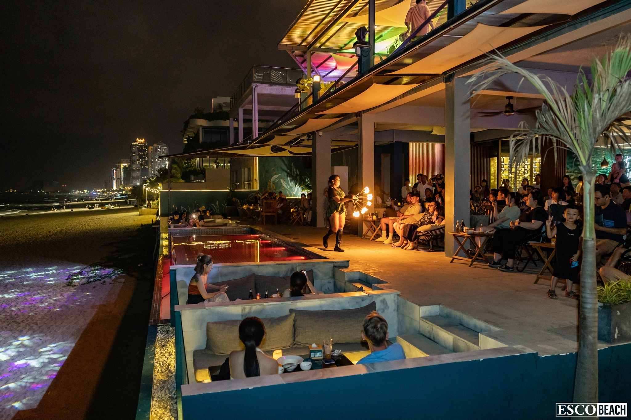 Esco Beach club với ghế lười colorful và sân khấu biểu diễn